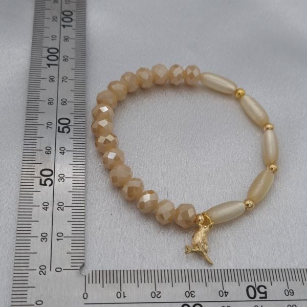 Handgemaakte armband met vergulde bedel - beige